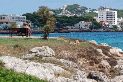 Sitzbank mit Urlaubern an der Ostkueste von Mallorca