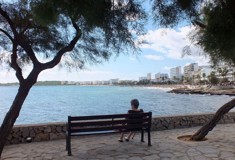 Sitzbank mit Urlauberin auf der Promenade