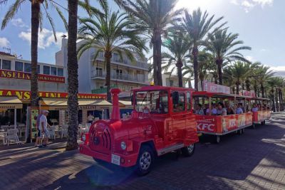 Mini-Eisenbahn mit Urlaubern unter Palmen an der Playa de Palma